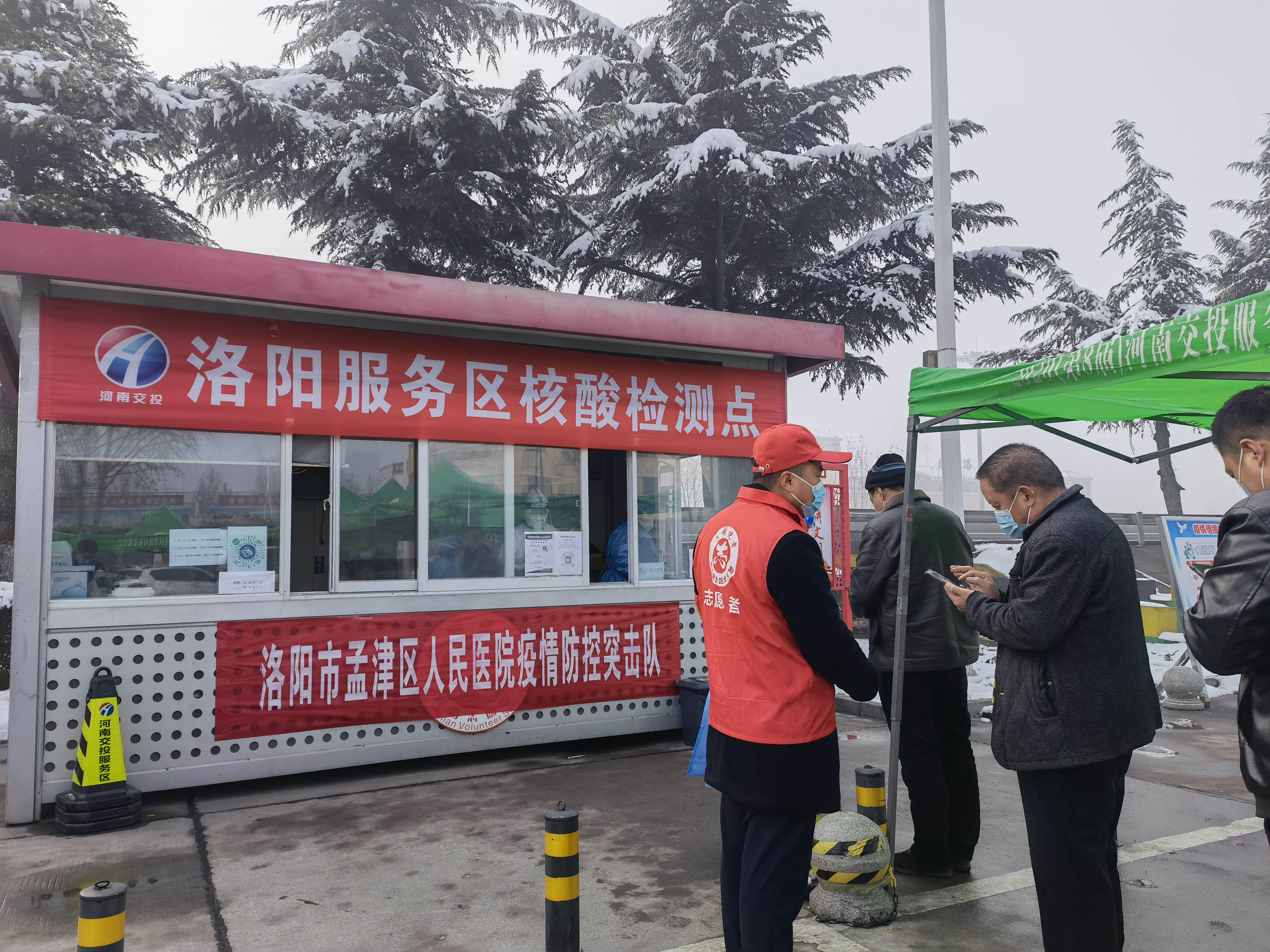 1月25日，洛陽服務區(qū)黨員志愿者為指引司乘人員填寫核酸檢測信息。 周黃偉 攝.jpg