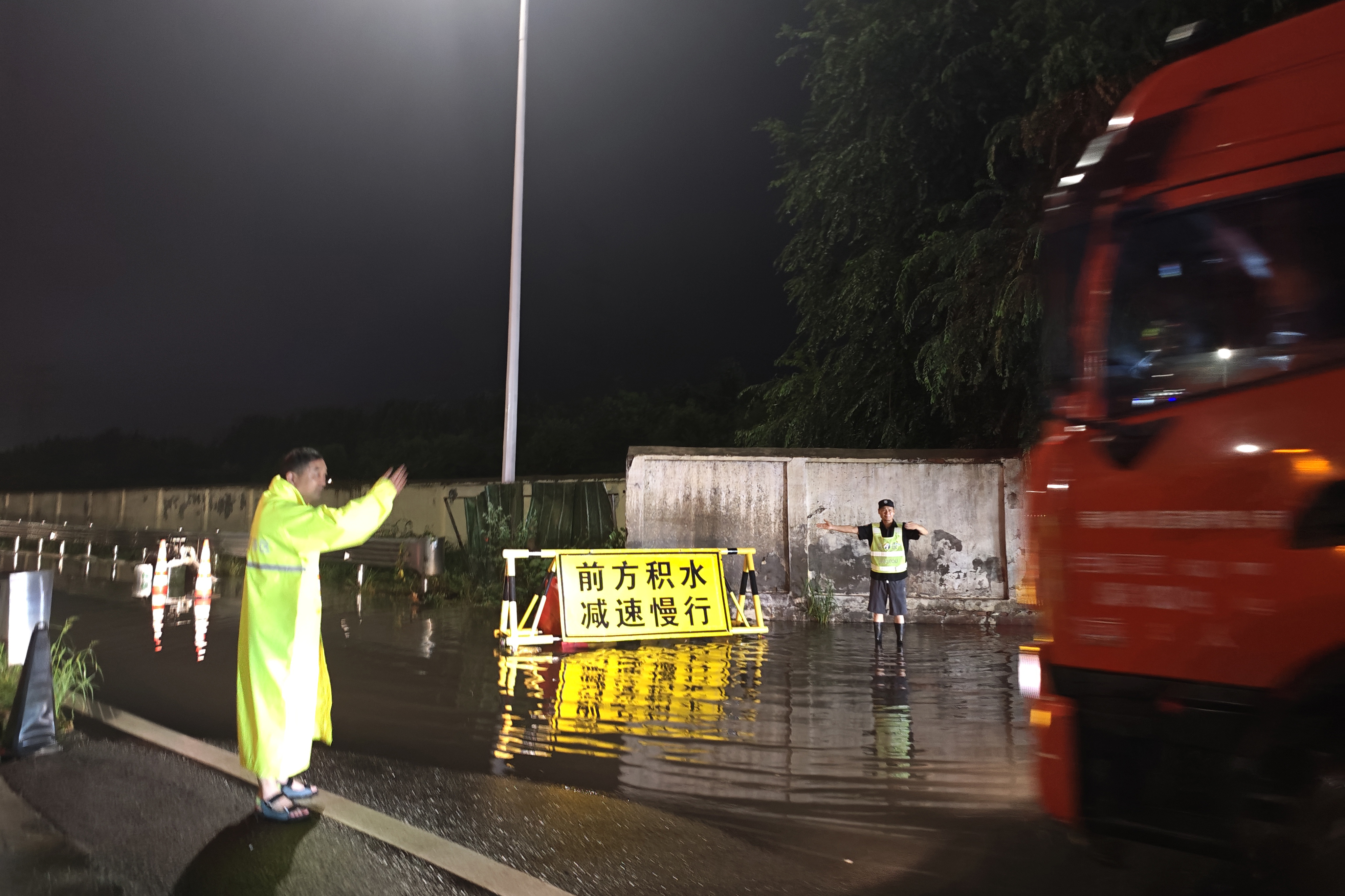 7月15日晚，2050分，鄭州東服務(wù)區(qū)監(jiān)管辦主任帶領(lǐng)值班人員冒雨排查積水點抽水作業(yè)，并指揮車輛順利通行。（攝像：王雅13949144133）.jpg